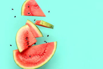 Flying pieces of fresh watermelon and seeds on turquoise background