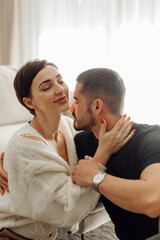 Fototapeta premium Passionate couple embracing tenderly at home, sharing intimate moment