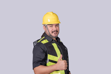 Smiling construction foreman in safety vest and helmet gives a thumbs up, showing approval, confidence, and positive site attitude.
