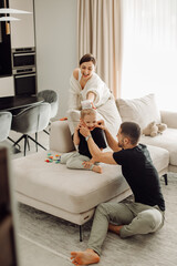 Happy family playing together on sofa in living room