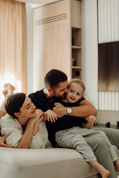 Happy family embracing and cuddling on sofa in living room