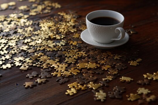 White Coffee Cup on Wooden Table with Gold Jigsaw Puzzle Pieces - Powered by Adobe