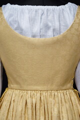 Elegant close up of a golden Renaissance-style dress showcasing delicate patterns and intricate lacing, reflecting traditional craftsmanship. For themes involving renaissance and historical fashion