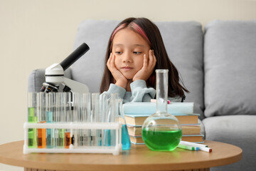 Cute little girl with scientific equipment at home
