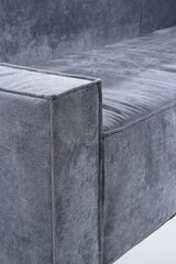 Detailed view showcasing a contemporary gray sofa with textured fabric, emphasizing modern interior...