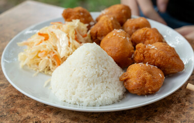 Fried chicken balls with rice and fresh cabbage salad closeup. Deep fried dough balls