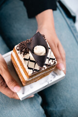 A Slice Of Cake Topped With Chocolate On Top With An Elegant Background Looks Aesthetic And Very Appetizing.