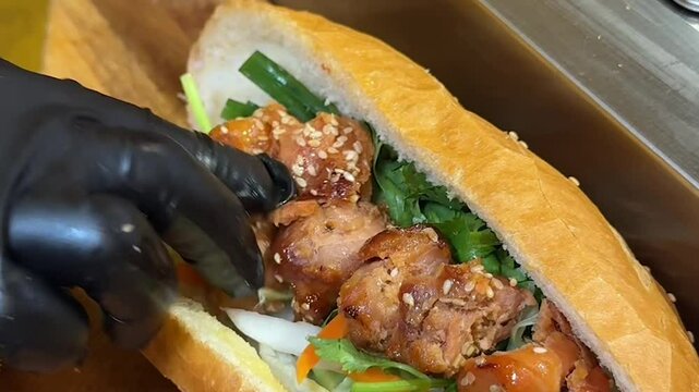 Grilled Meat Skewers Being Placed into Vietnamese B&aacute;nh M&igrave; Sandwich