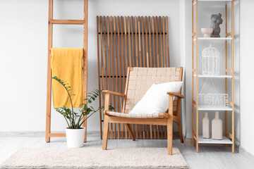 Interior of living room with wooden ladder, armchair and shelf unit