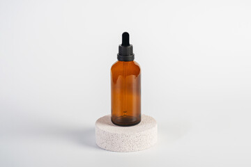 Cosmetic bottles made of dark amber glass and hand on white background