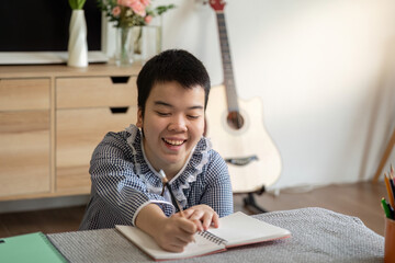 Back to School and Creative Learning. A teenage girl with Down syndrome joyfully engages in her...
