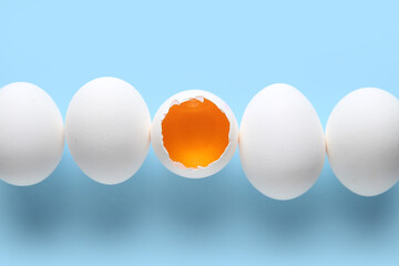 Raw chicken eggs on blue background