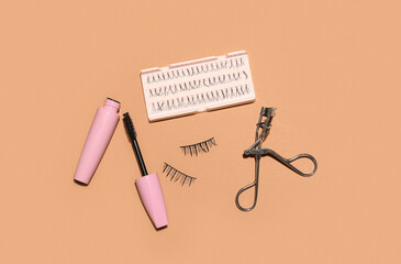 Different false eyelashes with mascara and curler on beige background