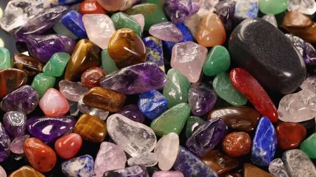 Vibrant Chakra Stones Gently Shaking on Black Surface