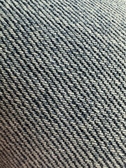Close-up shot of a blue denim fabric texture. The intricate weave of the textile is visible, showcasing the detailed pattern