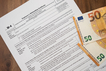 Obraz premium Necessary W-4 form with euro bills on company table essential for worker to indicate federal tax withholding preferences to employer to comply with law to avoid fine