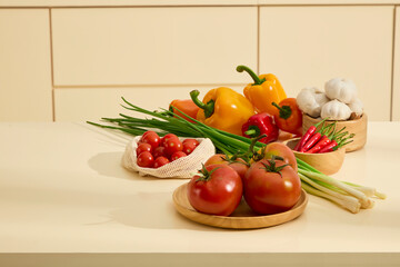 Vegetables are placed in wooden bowls, shown on the kitchen counter. Bell peppers, garlic, chili peppers and tomatoes are all fresh and colorful. A bunch of green onions is placed in the middle.