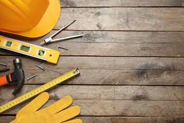 Hardhat and construction tools on wooden background