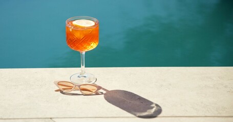 Cocktail, space and swimming pool with sunglasses and alcohol for summer holiday or vacation. Travel, resort and drink by water for outdoor luxury, hotel hospitality and shades to relax or chill