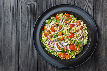 Barley salad with vegetables and walnuts in a bowl