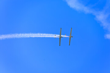 two planes synchronously flying during an aerial performance on the beatiful semi clear blue summer...