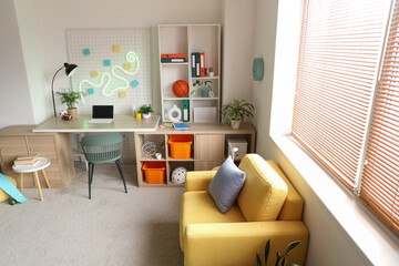 Interior of teenager's room with workplace, shelf unit and workplace