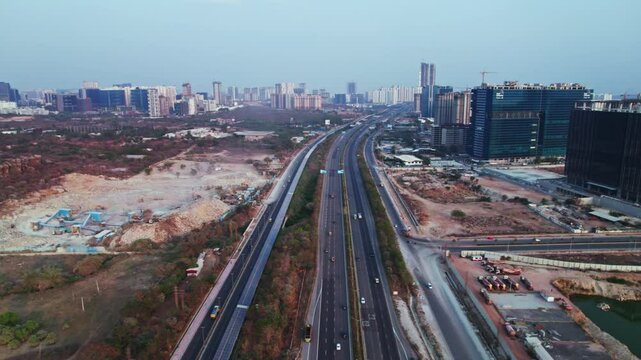 concrete mining with Glass facade buildings and hyderabad outer ring road at day time, semi circle, drone shot, 4k.