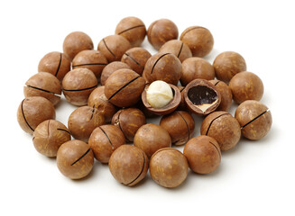 Shelled and unshelled macadamia nuts on white background