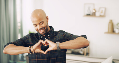 Happy man, heart hands and love with emoji for emotion, care or romantic gesture at home. Male person, smile or like with sign, shape or icon for commitment, compassion or valentines day at house