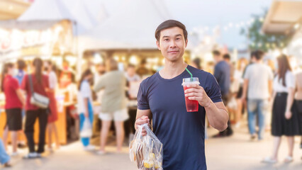 An Asian young man travels with street food.