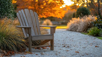 Rustic wooden Adirondack chair on a gravel pathway in an autumn garden.