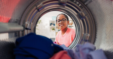 Camera placed inside drum captures moment girl packs colored clothes into washer. She gently shuts door, presses start button and exits the laundry room.