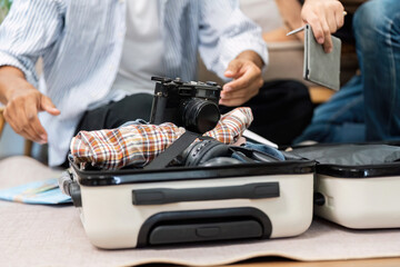 Essentials for a Journey. A couple packing their suitcase with travel items, showcasing their shared excitement and preparation for their trip.