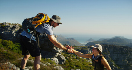 Couple, hiking or helping hand with support on mountain for trekking journey or adventure in...