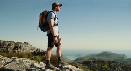 Hiking, fitness and thinking with man in nature for cliff, travel adventure and health. Space, reflection and vacation with person outdoor view on mountain for trekking holiday, explore and peace