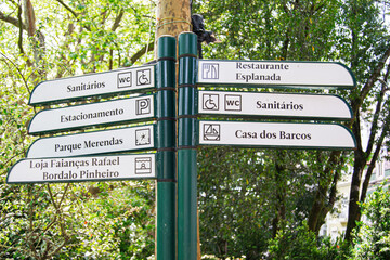 Directional signpost in Caldas da Rainha park with various location guides displayed