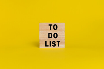 to do list words text on wooden blocks isolated on yellow background. copy space