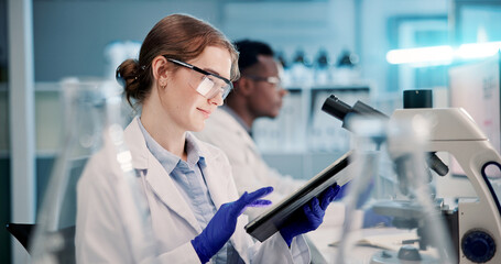 Scientist, woman and tablet with research in laboratory for medical study, clinical trial and data...