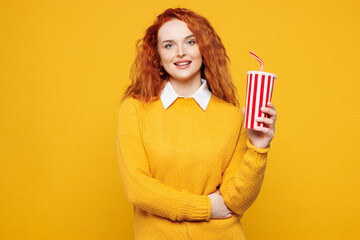 Young smiling happy fun redhead woman she wear sweater white shirt casual clothes hold in hand cup...