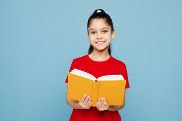 Obraz premium Little smart happy kid girl 8-9 years old wears red t-shirt have fun holding read book isolated on pastel light blue color background child studio portrait. Mother's Day love family lifestyle concept.