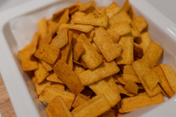 Golden Crispy Snacks in White Container, Perfect for Snacking