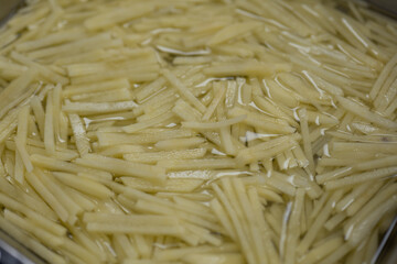Freshly Shredded Potatoes Soaked in Water for Cooking Preparation