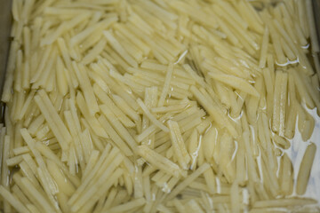 Freshly Shredded Potatoes Soaked in Water for Cooking Preparation