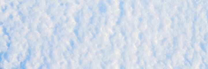 Natural snow texture. The surface of the snow crust. Snowy ground. Winter background with snow patterns. Perfect for Christmas and New Year design. Closeup top view.