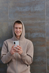 Fototapeta premium Teenager boy with smartphone, casual teen with device, young guy on black wall background