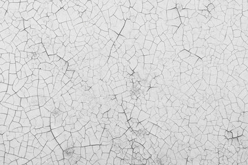 White peeling paint on the wall. Old concrete wall with cracked flaking paint. Weathered rough painted surface with patterns of cracks and peeling. High resolution texture for background and design.
