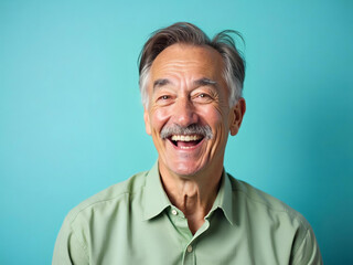 Radiant Smile of a Mature Man Emanating Joy Against a Turquoise Backdrop
