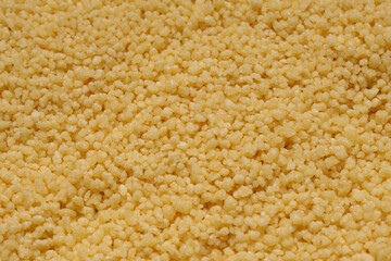 Raw organic couscous as a background, top view. Close-up view.