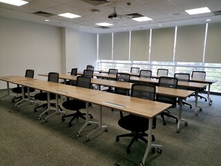 An empty Meeting or training room with wooden table and black chairs.Empty Trainer's Seat in the...
