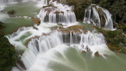Aerial View of a Multi-Tiered Waterfall in a Lush Green Landscape © 陈佳乐